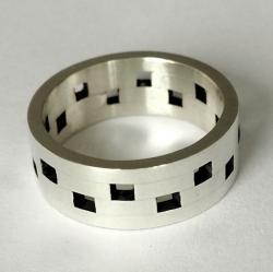 Zilveren ring met versprongen vierkantjes.