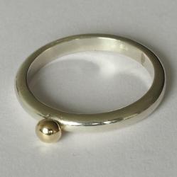 Zilveren ring met geelgouden bolletje.